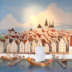 Bild på en modell av medeltidsstad med vita hus och hamn