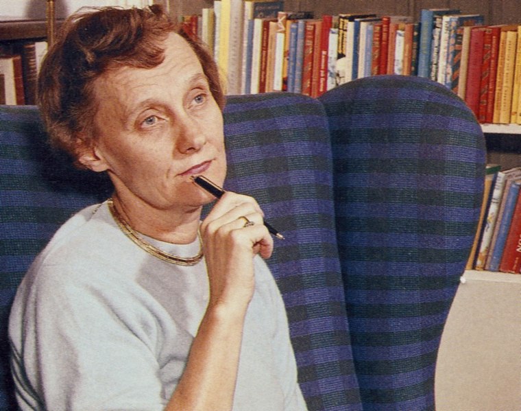 En porträttbild på Astrid Lindgren, sittandes i en fåtölj med en penna i handen.