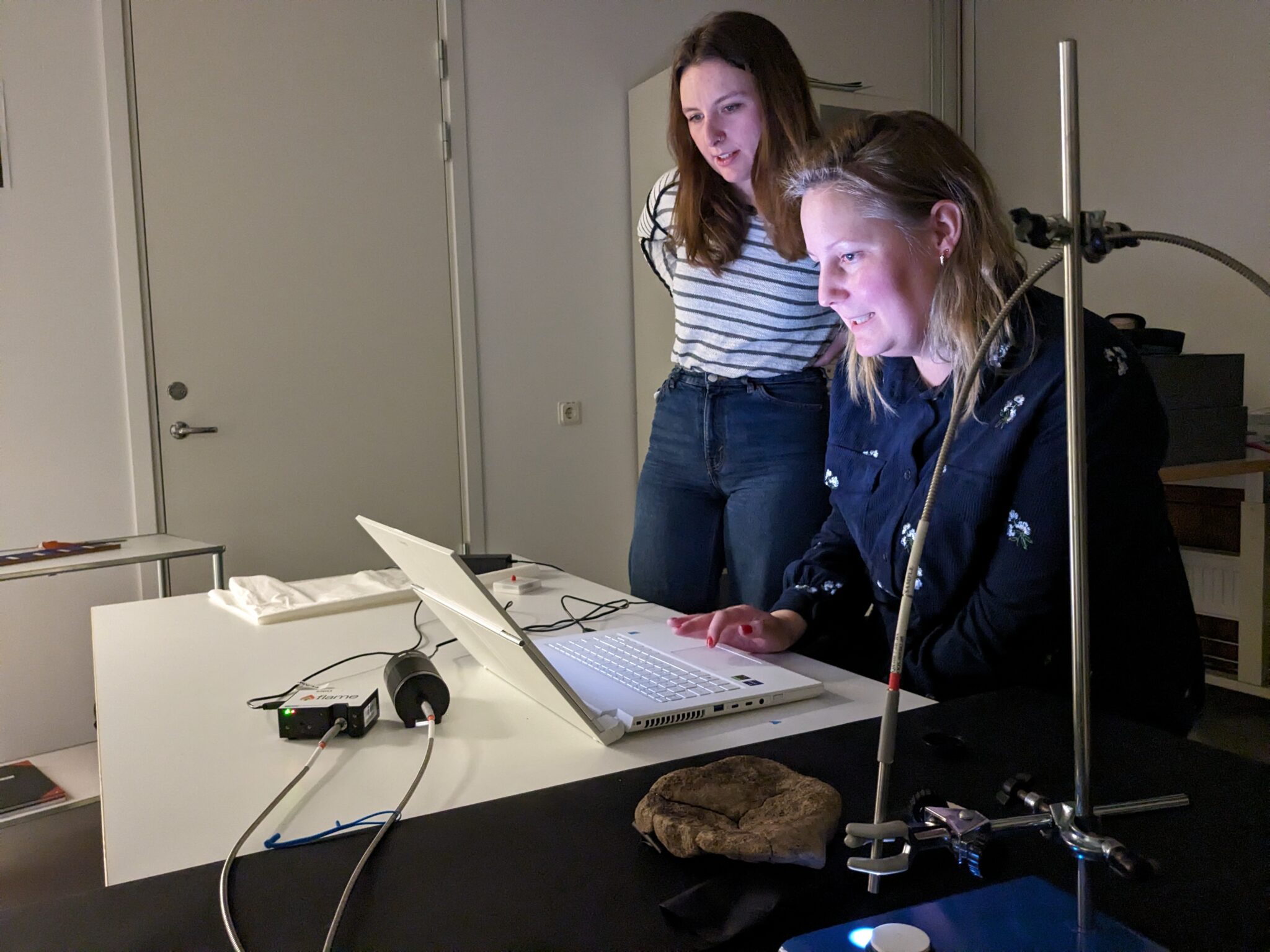 Två kvinnor tittar tillsammans på en bildskärm