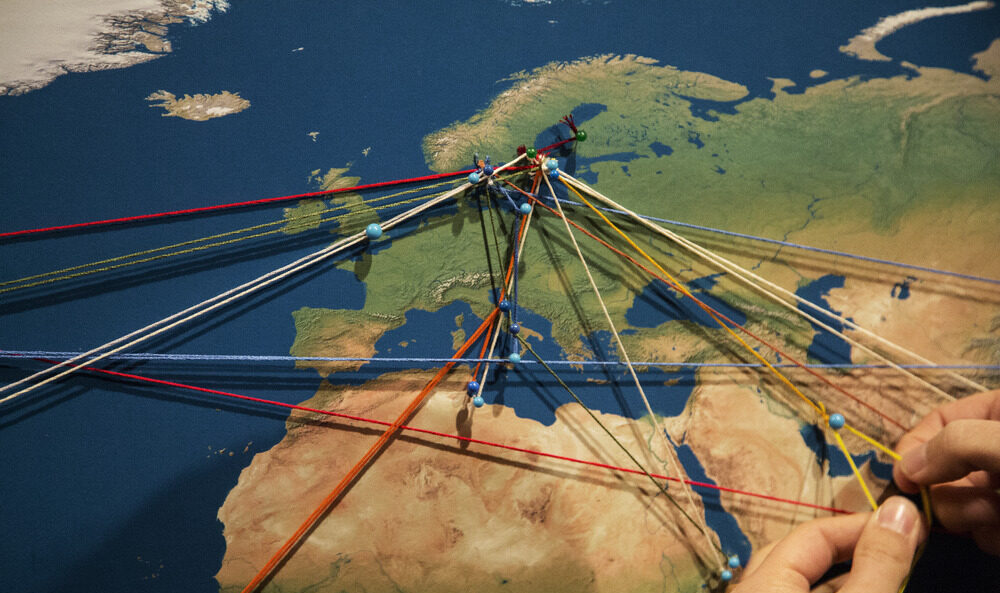 En karta med nålar och emellan dem färgglada snören som utgår från Sverige och ut i Europa.