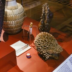 Detalj från museimonter med ett antal föremål och en mätdosa i mitten.