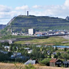 Vy över stad med en gruva i bakgrunden.