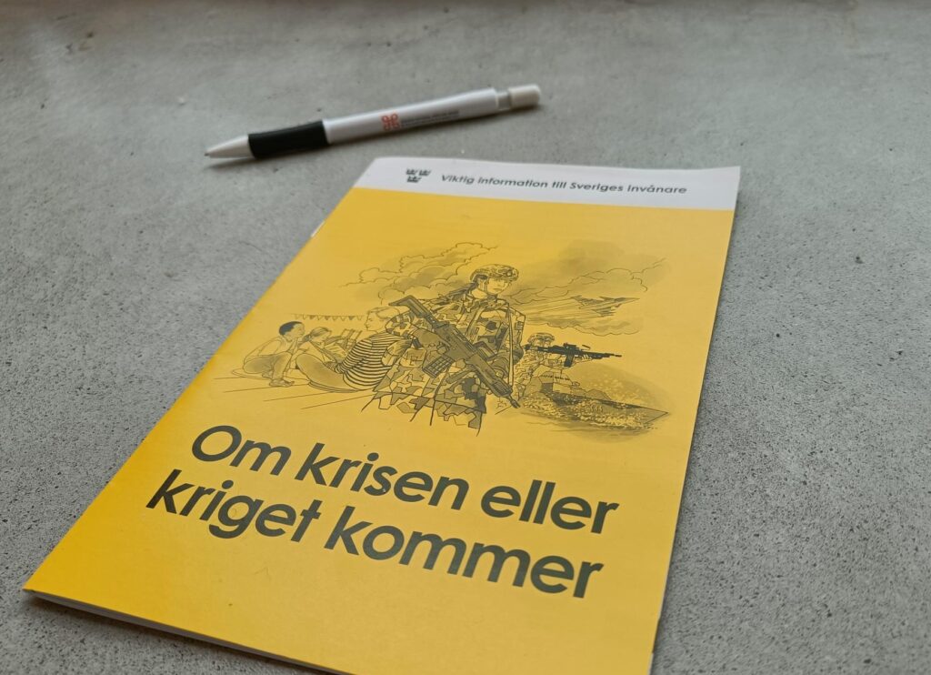 Beredskapsbroschyren för om krisen eller kriget kommer, tillsammans med en penna med Riksantikvarieämbetets logotyp, en "kringla", på.