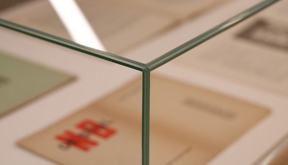 Ett övre hörn av en glasmonter, samt ett suddigt innehåll i montern.