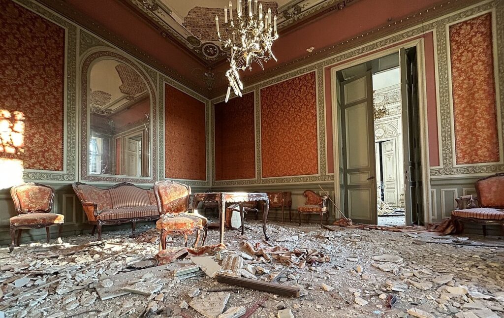 Ett rum med skadade kulturhistoriska föremål och interiör och där golvet är skadat, splittrat och uppbrutet.