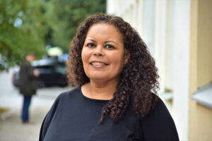 Porträttbild på kvinna som står utomhus i en gatumiljö