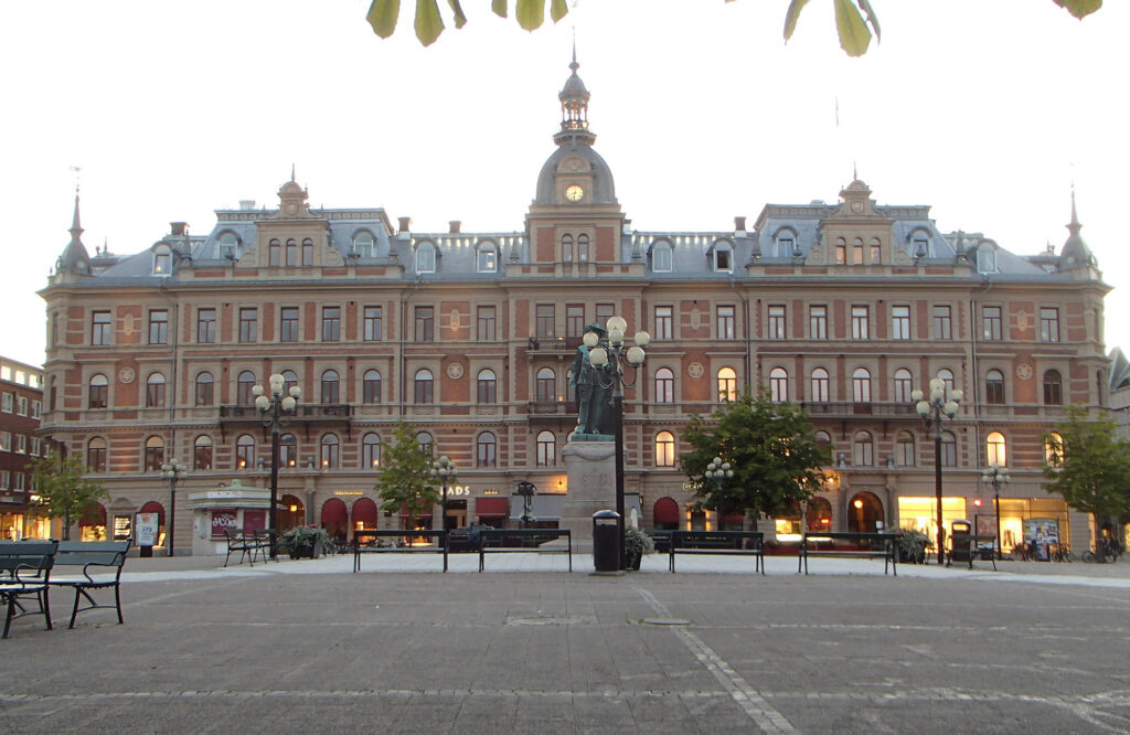 Pampig tegelbyggnad med tinnar och klocktorn.