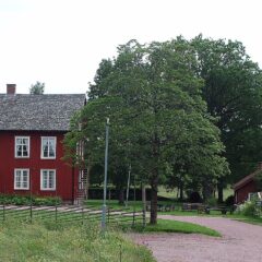 Röda träbyggnader med vita fönster.