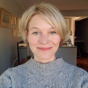 Porträtt, inne, kvinna, blond och korthårig, grå tröja.