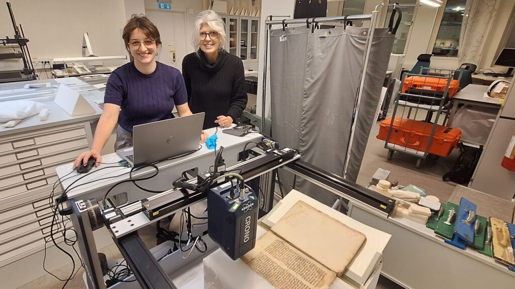 Två forskare i ett rum där analyser genomförs med hjälp av en dator kopplad till en maskin som genomför röntgenflourescens.