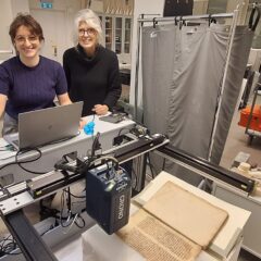 Två forskare i ett rum där analyser genomförs med hjälp av en dator kopplad till en maskin som genomför röntgenflourescens.
