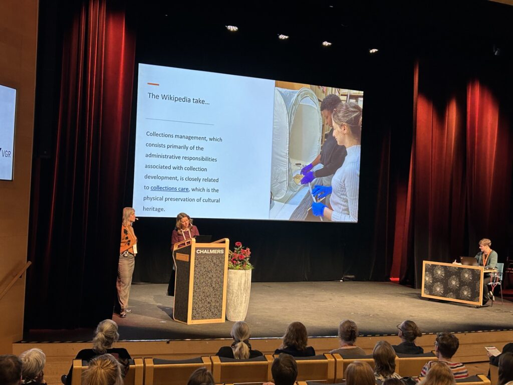 Två kvinnor håller ett föredrag vid ett podium på en scen.