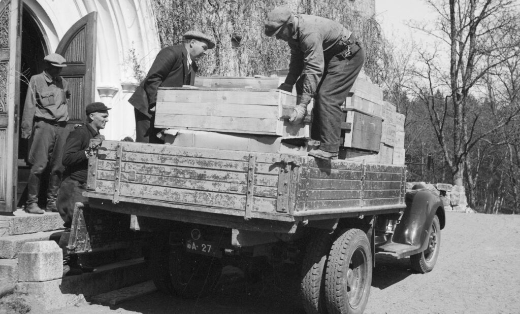 Män som lyfter upp trälådor på en lastbil