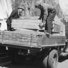 Män som lyfter upp trälådor på en lastbil