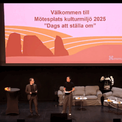 En man och en kvinna står på en scen inför en publik.