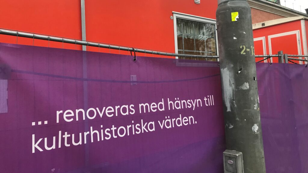 Banderoll på byggnad som informerar om att varsam renovering pågår.