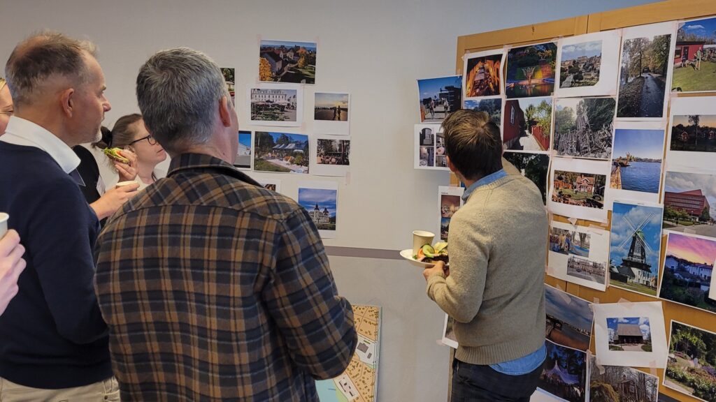 En grupp människor står framför en tavla med bilder uppsatta på.