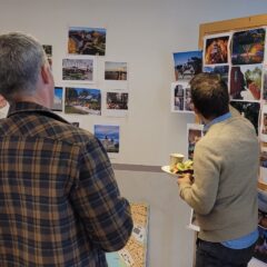 En grupp människor står framför en tavla med bilder uppsatta på.