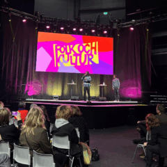 Människor sitter och lyssnar på föreläsaren på en scen