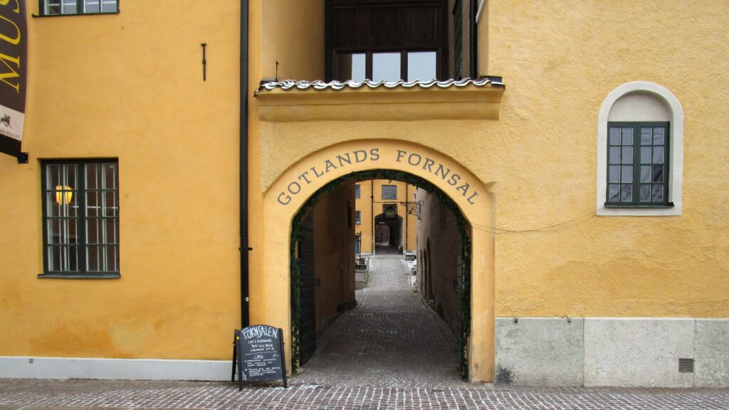 Entré i valvbåge på gulputsad fasad.