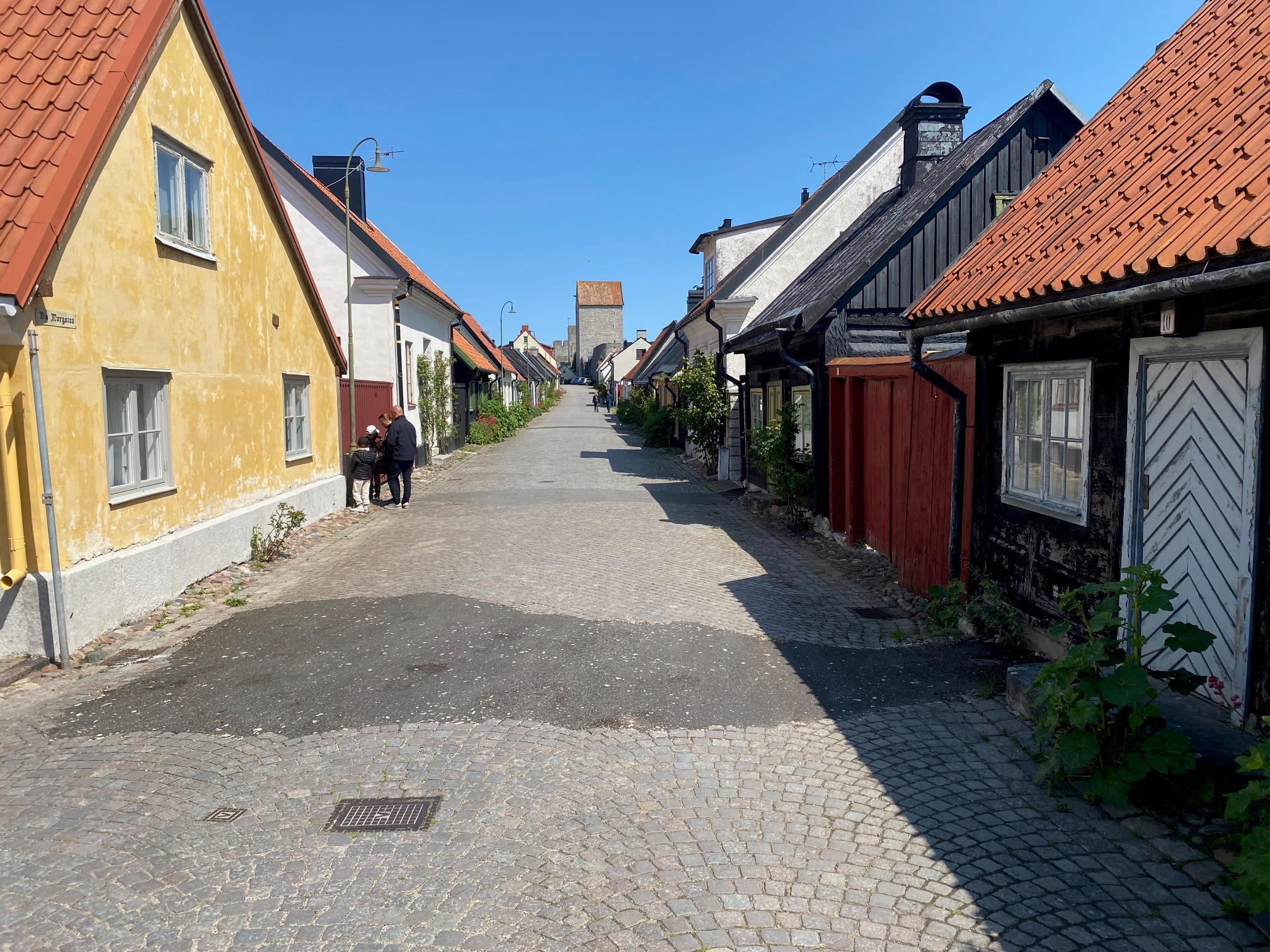 Smal gata belagd med gatsten i småstad med äldre bebyggelse, en- och tvåvåningshus.