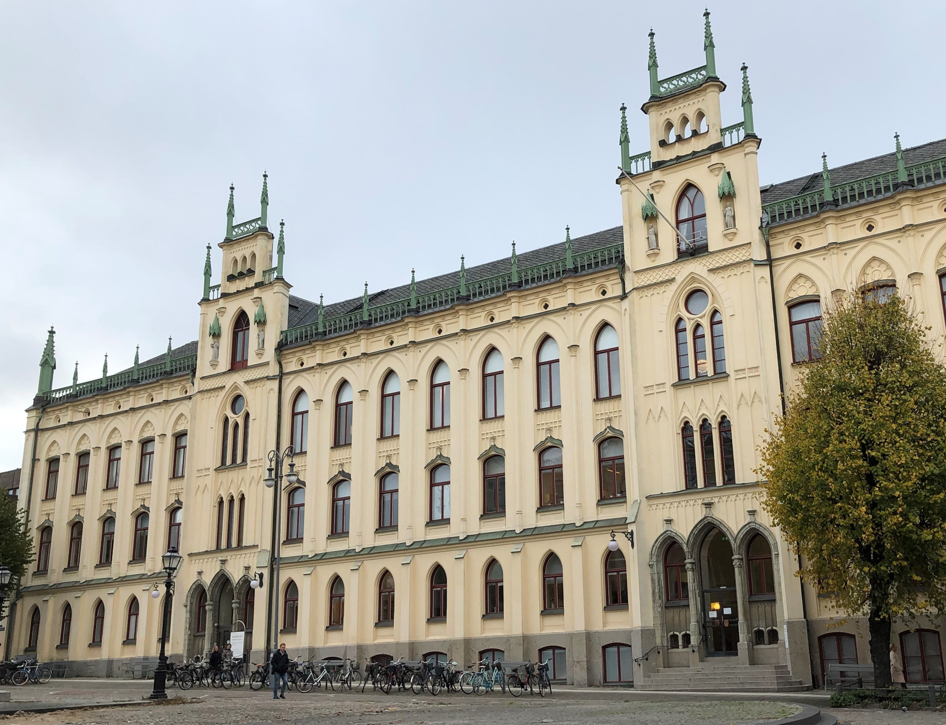 Stor, äldre byggnad i tre våningar, med gul putsad fasad och rika byggnadsdetaljer.