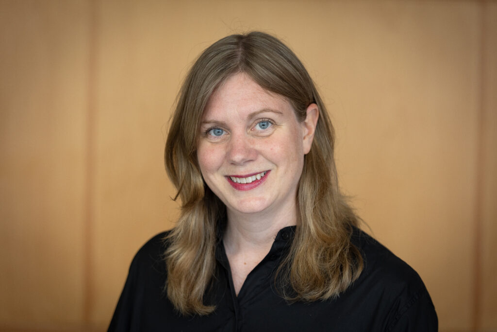 Porträttbild av långhårig leende kvinna.