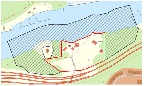 Karta med ett markerat område i rött som omsluter flera byggnader, en väg och omgivande grön- och strandzon intill vattnet