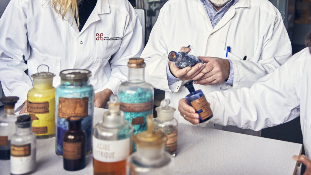 Händer på personer som undersöker flaskor med olika typer av innehåll.