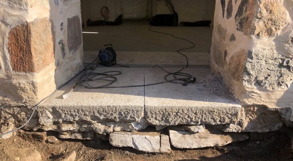 Sandfärgad stentrapp med svarta kablar ovanpå