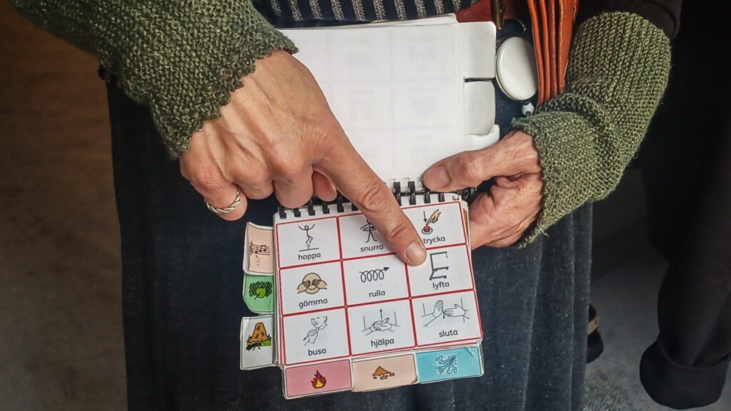 Händer som pekar på papper med illustrationer.