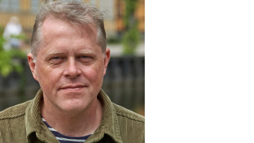 Porträttfoto taget utomhus på man med manchesterskjorta.