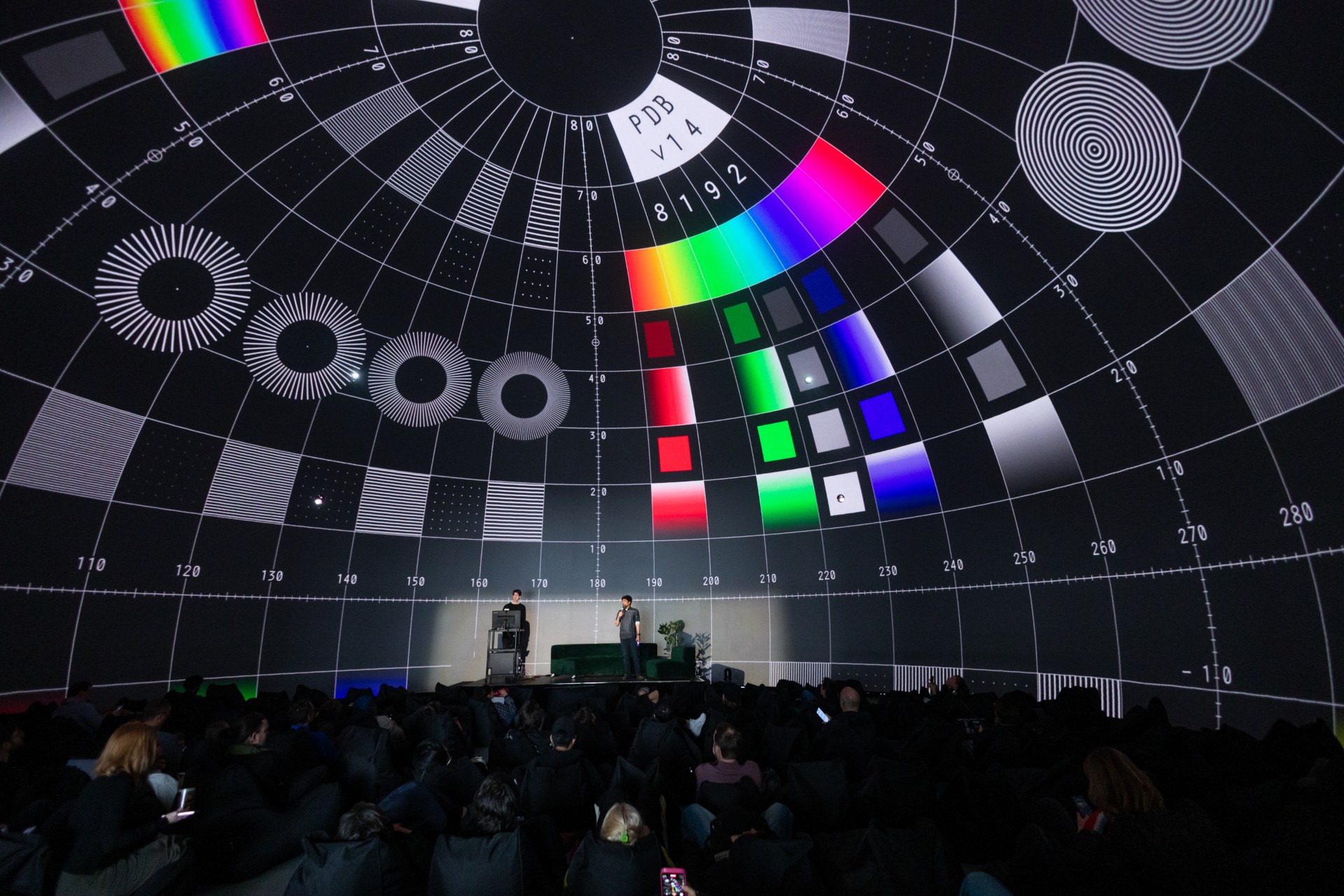 En mörk dom fotograferad inifrån, med projektioner i färg.