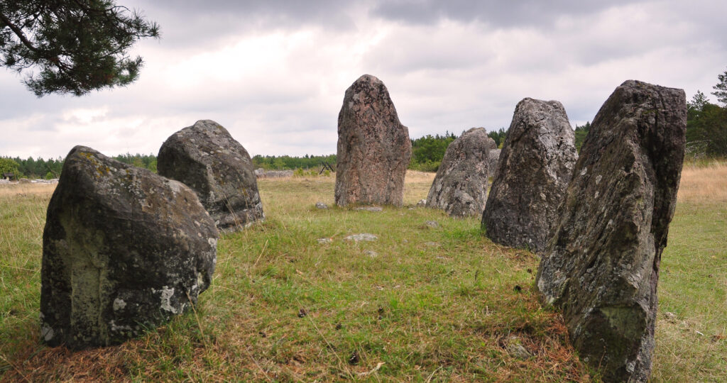 Stora grå stenar i en ring på grönt gräs