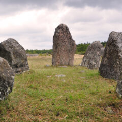 Stora grå stenar i en ring på grönt gräs