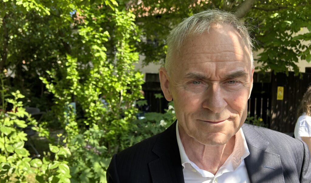 Porträtt på man framför grön buske