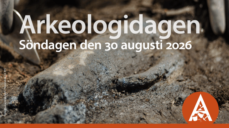 Närbild på arkeologiskt fynd, en slags kanna som ligger halvt dold i jorden. På bilden ligger text med datum samt en symbol i orange.