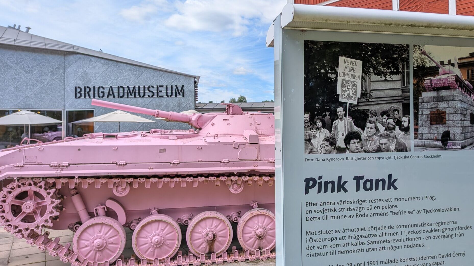 En rosa stridsvagn med larvfötter. Och en skylt framför som berättar om konstverket.