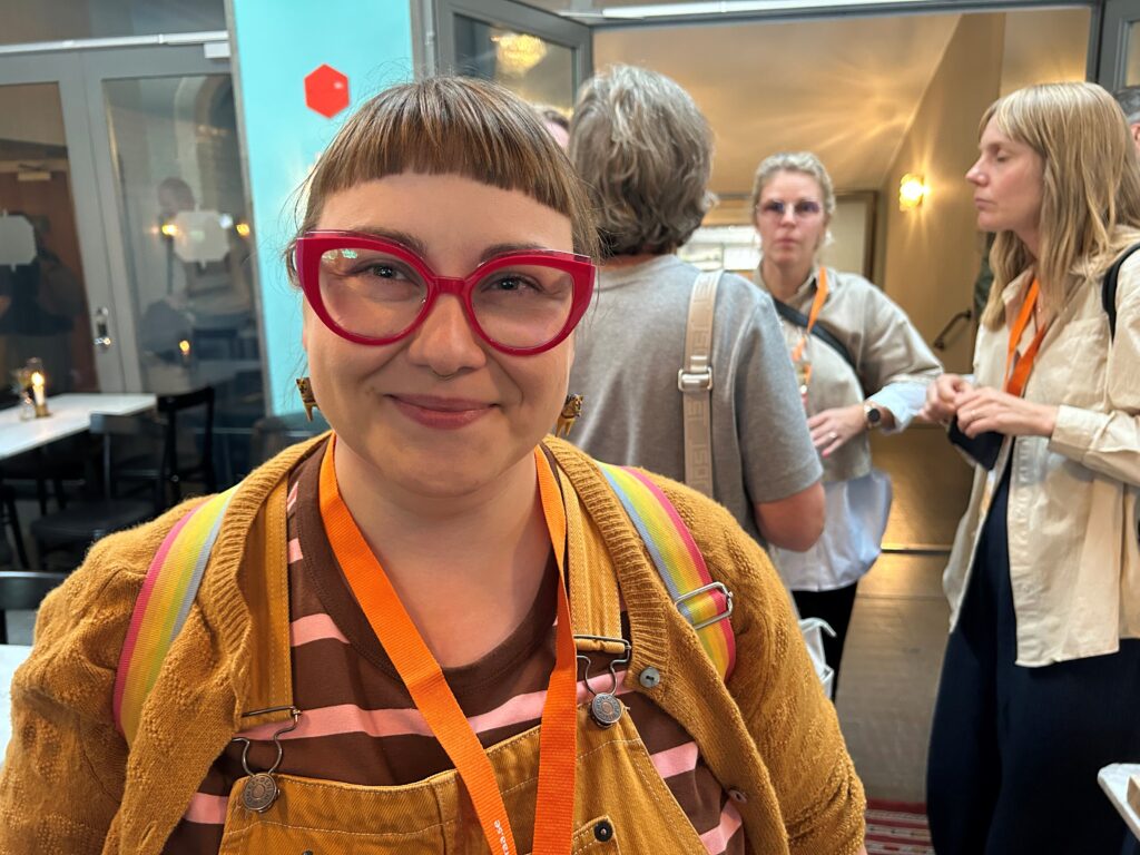 Glasögonprydd kvinna ser in i kameran.
